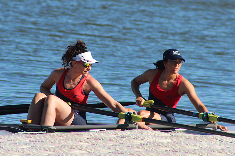 Two women at dock in double sculling shell