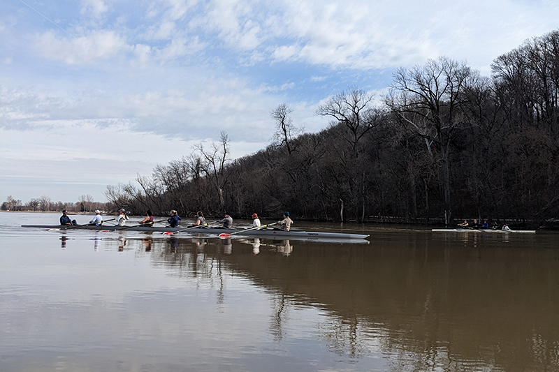 Two 8 person rowing shells on a lake